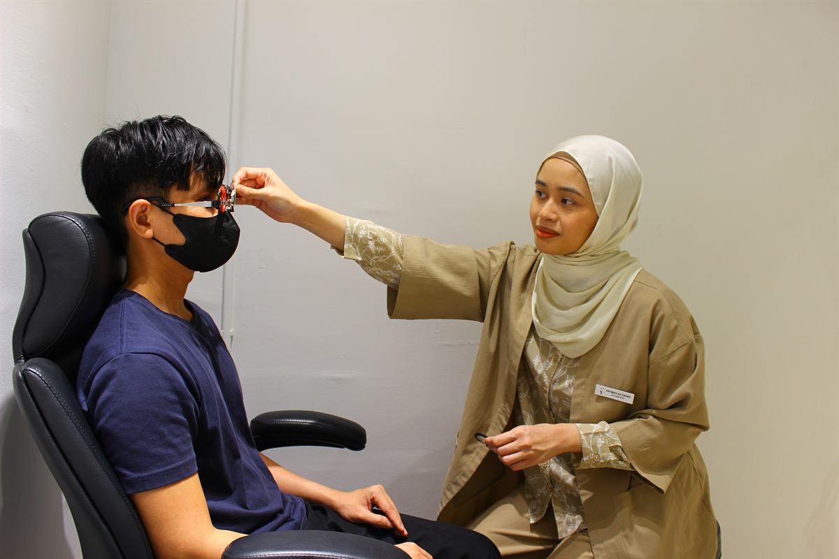 Optometrist adjusting trial lenses during an eye examination